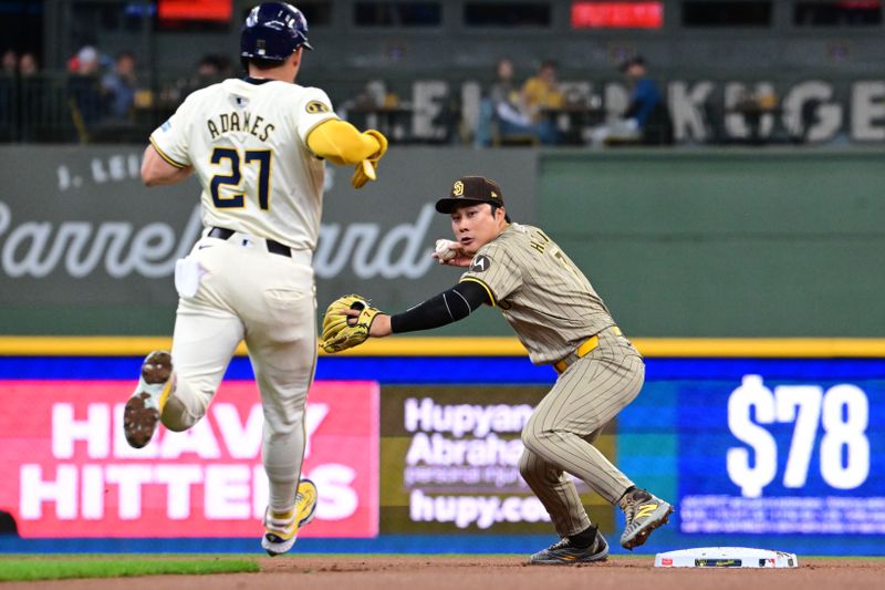 Apr 17, 2024; Milwaukee, Wisconsin, USA; San Diego Padres shortstop Ha-seong Kim (7) completes a double play after forcing out Milwaukee Brewers shortstop Willy Adames (27) in the first inning at American Family Field. Mandatory Credit: Benny Sieu-USA TODAY Sports