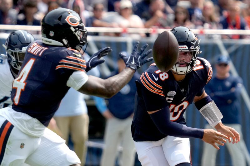 Chicago Bears quarterback Caleb Williams, right, pitches the ball to running back D'Andre Swift during the first half of an NFL football game against the Tennessee Titans on Sunday, Sept. 8, 2024, in Chicago. (AP Photo/Nam Y. Huh)