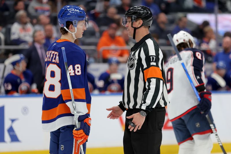 Mar 22, 2026; Elmont, New York, USA; New York Islanders defenseman Matthew Schaefer (48) talks to referee Frederick L'ecuyer (17) during the second period against the Columbus Blue Jackets at UBS Arena. Mandatory Credit: Brad Penner-Imagn Images