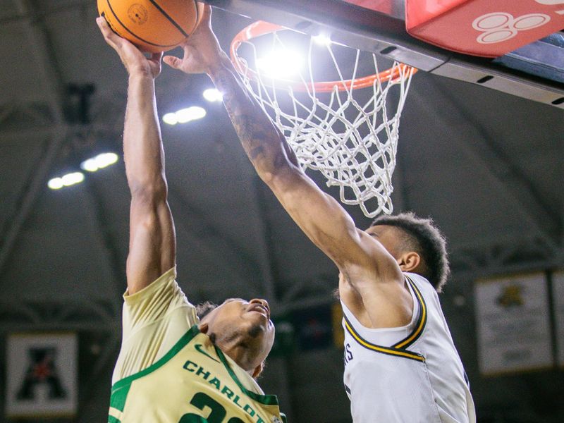 Jan 14, 2025; Wichita, Kansas, USA; Wichita State Shockers forward Ronnie DeGray III (3) blocks a shot by Charlotte 49ers guard Jaehshon Thomas (22) during the first half at Charles Koch Arena. Mandatory Credit: William Purnell-Imagn Images