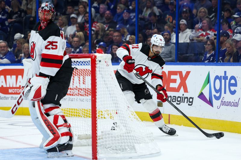 Nov 16, 2024; Tampa, Florida, USA; New Jersey Devils defenseman Jonas Siegenthaler (71) controls the puck against the Tampa Bay Lightning in the first period at Amalie Arena. Mandatory Credit: Nathan Ray Seebeck-Imagn Images