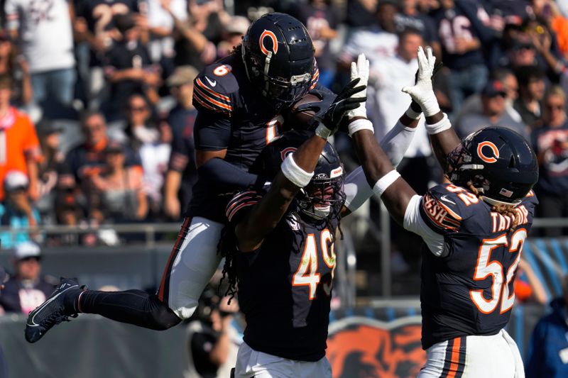 Chicago Bears cornerback Kyler Gordon (6) celebrates his fumble recovery with linebacker Tremaine Edmunds (49) and Darrell Taylor (52) against the Carolina Panthers during the second half of an NFL football game Sunday, Oct. 6, 2024, in Chicago. (AP Photo/Nam Y. Huh)