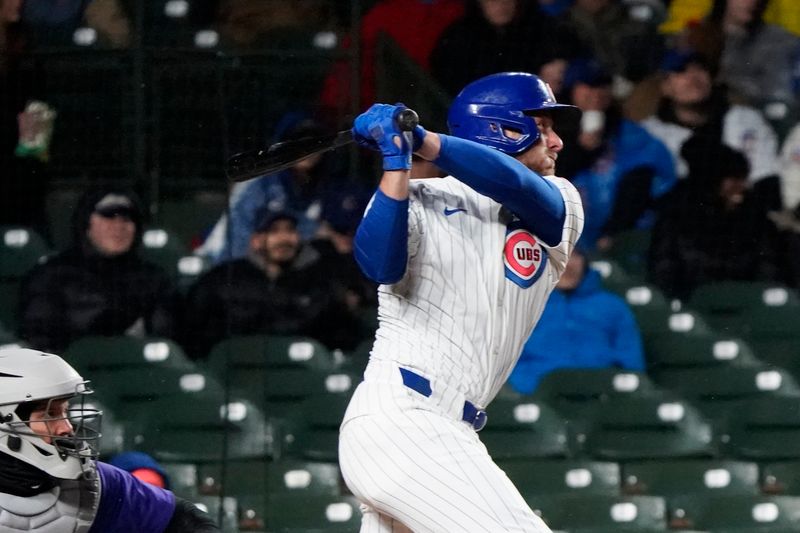 Apr 3, 2024; Chicago, Illinois, USA; Chicago Cubs first baseman Michael Busch (29) hits a one run sacrifice against the Colorado Rockies during the second inning at Wrigley Field. Mandatory Credit: David Banks-USA TODAY Sports