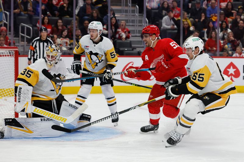 Oct 18, 2023; Detroit, Michigan, USA; Detroit Red Wings left wing David Perron (57) and Pittsburgh Penguins defenseman Erik Karlsson (65) fight for position in front of goaltender Tristan Jarry (35) in the second period at Little Caesars Arena. Mandatory Credit: Rick Osentoski-USA TODAY Sports