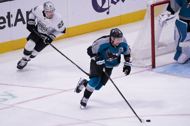 Nov 20, 2025; San Jose, California, USA;  San Jose Sharks defenseman Dmitry Orlov (9) advances the puck past Los Angeles Kings left winger Kevin Fiala (22) in the third period at SAP Center at San Jose. Mandatory Credit: David Gonzales-Imagn Images