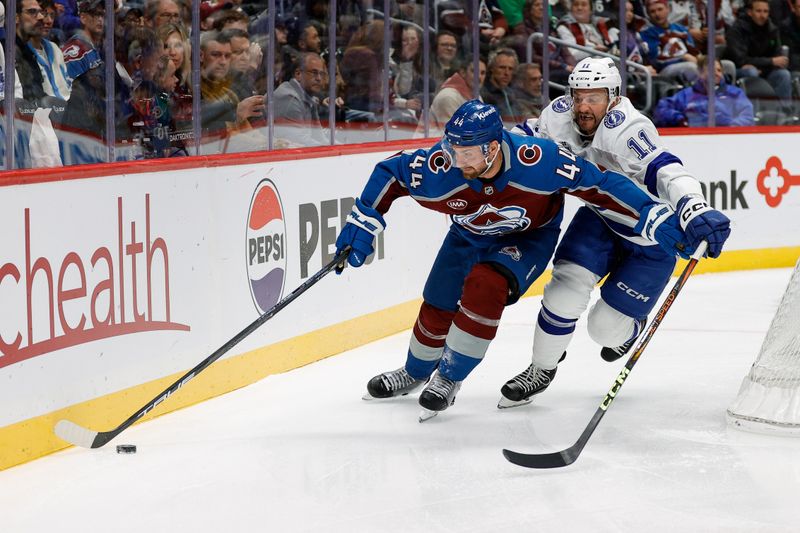 Oct 30, 2024; Denver, Colorado, USA; Colorado Avalanche defenseman Calvin de Haan (44) and Tampa Bay Lightning center Luke Glendening (11) battle for the puck in the first period at Ball Arena. Mandatory Credit: Isaiah J. Downing-Imagn Images