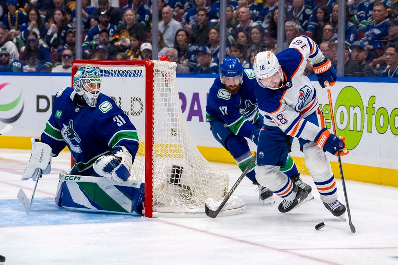 May 10, 2024; Vancouver, British Columbia, CAN; Vancouver Canucks goalie Arturs Silvos (31) watches as defenseman Filip Hronek (17) stick checks Edmonton Oilers forward Zach Hyman (18) during the first overtime in game two of the second round of the 2024 Stanley Cup Playoffs at Rogers Arena. Mandatory Credit: Bob Frid-USA TODAY Sports