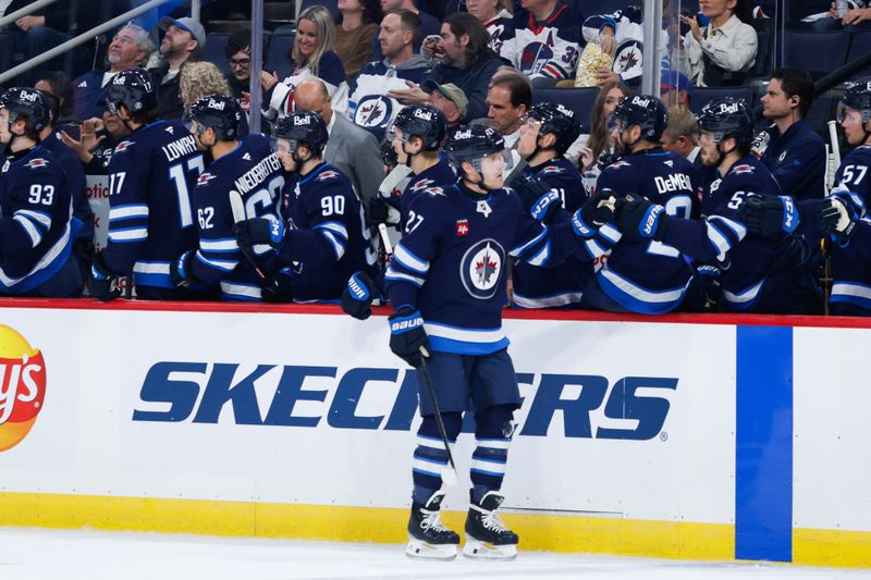 Oct 2, 2024; Winnipeg, Manitoba, CAN;  Winnipeg Jets forward Nikolaj Ehlers (27) is congratulated by his team mates on his goal against  Calgary Flames goalie Dustin Wolf (32) during the first period at Canada Life Centre. Mandatory Credit: Terrence Lee-Imagn Images