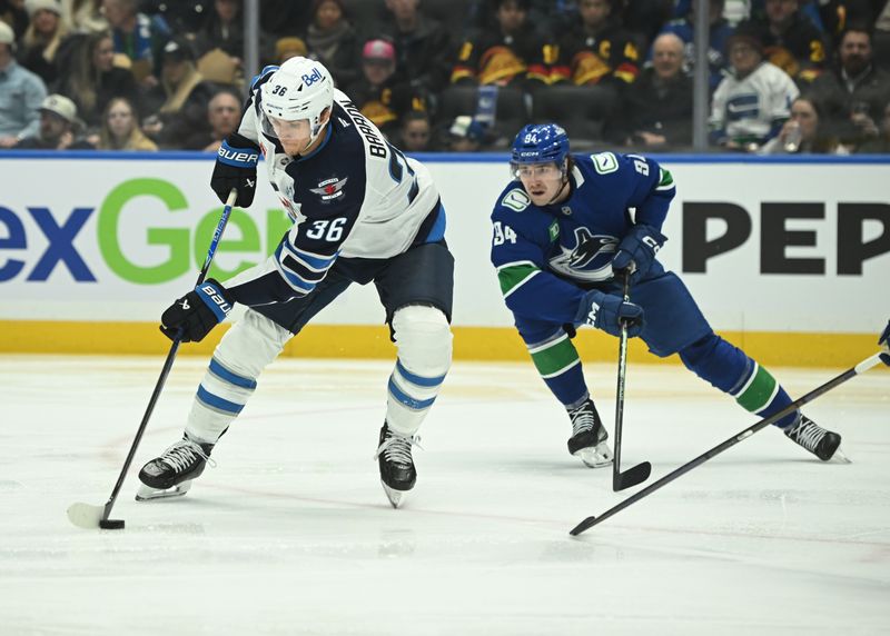 Feb 25, 2026; Vancouver, British Columbia, CAN; Winnipeg Jets center Morgan Barron (36) skates with the puck against from Vancouver Canucks center Linus Karlsson (94) during the second period at Rogers Arena. Mandatory Credit: Simon Fearn-Imagn Images