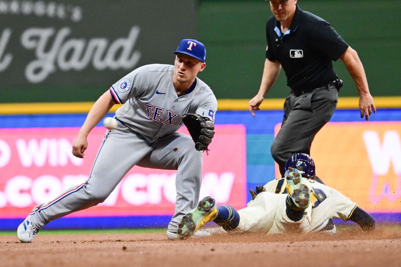 Jun 25, 2024; Milwaukee, Wisconsin, USA; Milwaukee Brewers center fielder Blake Perkins (16) steals second base before a tag by Texas Rangers shortstop Corey Seager (5) in the sixth inning at American Family Field. Mandatory Credit: Benny Sieu-USA TODAY Sports