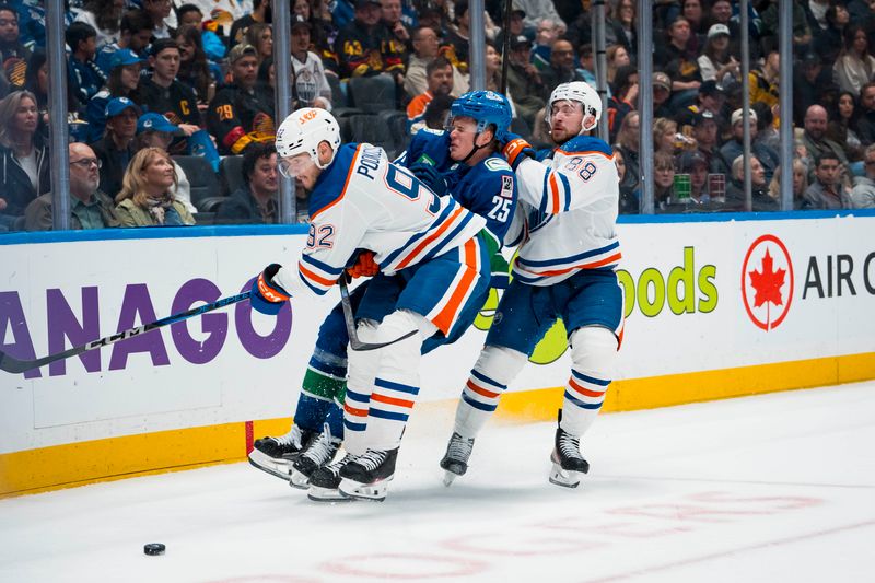 Oct 3, 2025; Vancouver, British Columbia, CAN; Edmonton Oilers forward Vasily Podkolzin (92) and forward Andrew Mangiapane (88) check Vancouver Canucks defenseman Elias Pettersson (25) in the second period at Rogers Arena. Mandatory Credit: Bob Frid-Imagn Images