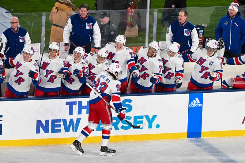 Feb 18, 2024; East Rutherford, New Jersey, USA;  New York Rangers center Mika Zibanejad (93) celebrates his game tying goal against the New York Islanders with th ethe New York Rangers  bench during the third period in a Stadium Series ice hockey game at MetLife Stadium. Mandatory Credit: Dennis Schneidler-USA TODAY Sports