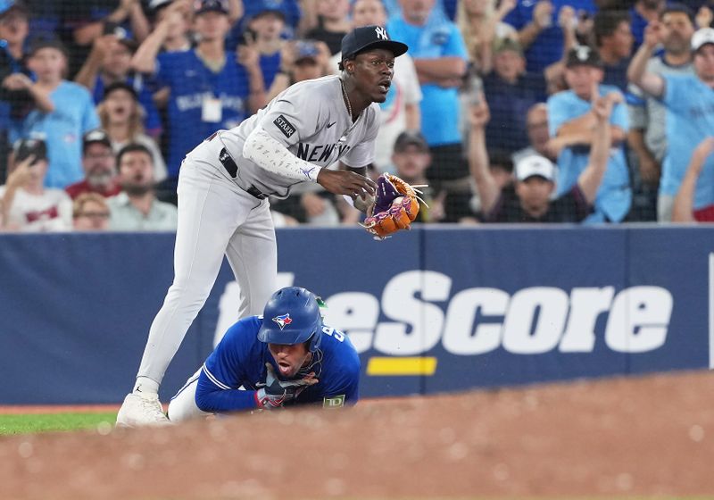 Jun 30, 2025; Toronto, Ontario, CAN; Toronto Blue Jays outfielder George Springer (4) grabs his throat after being tagged out at third base by New York Yankees third baseman Jazz Chisholm Jr. (13) during the sixth inning at Rogers Centre. Mandatory Credit: Nick Turchiaro-Imagn Images