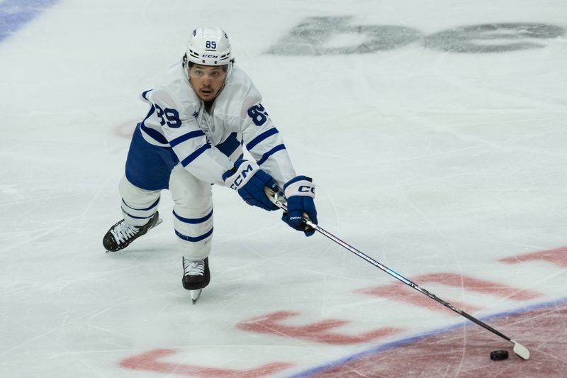 Jan 25, 2025; Ottawa, Ontario, CAN; Toronto Maple Leafs left wing Nicholas Robertson (89) reaches for the puck against the Ottawa Senators in the thid period at the Canadian Tire Centre. Mandatory Credit: Marc DesRosiers-Imagn Images