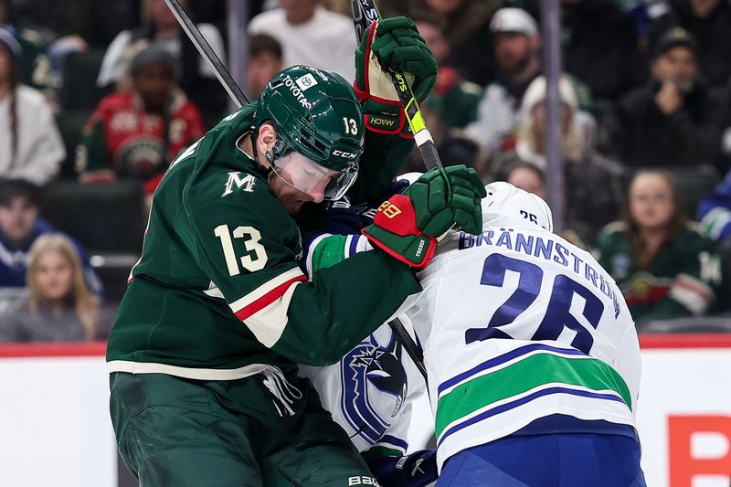 Dec 3, 2024; Saint Paul, Minnesota, USA; Vancouver Canucks defenseman Erik Brannstrom (26) checks Minnesota Wild center Yakov Trenin (13) during the second period at Xcel Energy Center. Mandatory Credit: Matt Krohn-Imagn Images