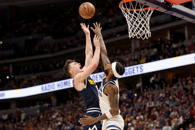 DENVER, COLORADO - APRIL 10: Christian Braun #0 of the Denver Nuggets puts up a shot over Nickeil Alexander-Walker #9 of the Minnesota Timberwolves during the first quarter at Ball Arena on April 10, 2024 in Denver, Colorado. NOTE TO USER: User expressly acknowledges and agrees that, by downloading and or using this photograph, User is consenting to the terms and conditions of the Getty Images License Agreement.  (Photo by Matthew Stockman/Getty Images)