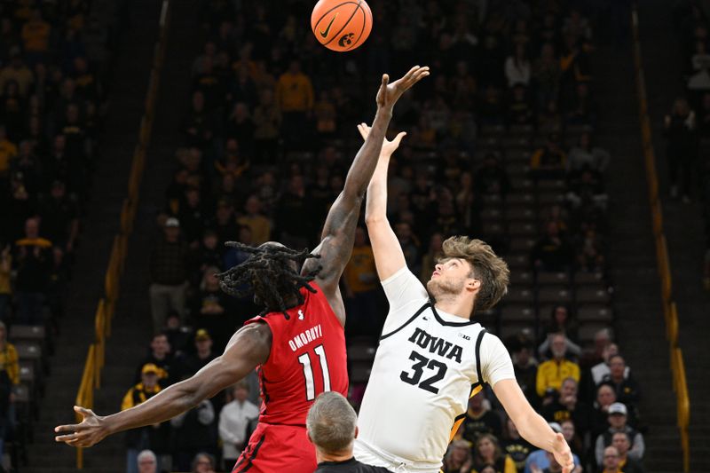 Jan 6, 2024; Iowa City, Iowa, USA; Iowa Hawkeyes forward Owen Freeman (32) and Rutgers Scarlet Knights center Clifford Omoruyi (11) battle for the opening tipoff during the first half at Carver-Hawkeye Arena. Mandatory Credit: Jeffrey Becker-USA TODAY Sports