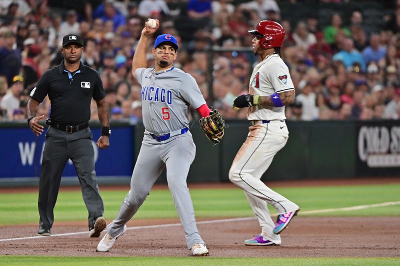 Apr 17, 2024; Phoenix, Arizona, USA;  Chicago Cubs third base Christopher Morel (5) turns a double play on Arizona Diamondbacks second base Ketel Marte (4) in the third inning at Chase Field. Mandatory Credit: Matt Kartozian-USA TODAY Sports