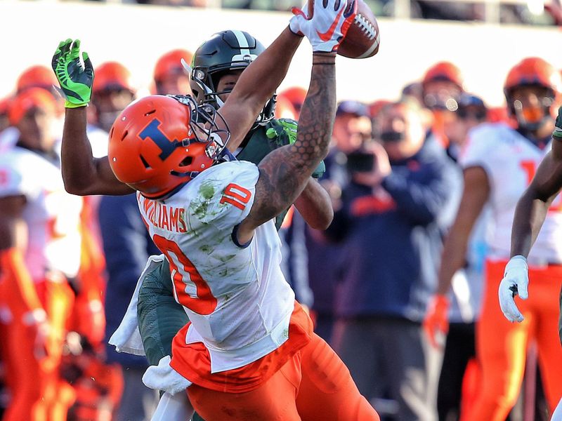 Nov 9, 2019; East Lansing, MI, USA; Illinois Fighting Illini tight end Justice Williams (10) makes a catch in front of Michigan State Spartans cornerback Josiah Scott (22) during the first quarter of a game at Spartan Stadium. Mandatory Credit: Mike Carter-USA TODAY Sports