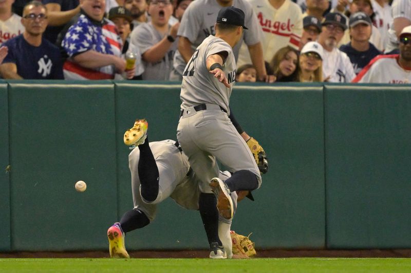 May 26, 2025; Anaheim, California, USA;  New York Yankees third baseman Oswald Peraza (18) and shortstop Anthony Volpe (11) avoid a collision as they go after a foul ball hit by Los Angeles Angels shortstop Kevin Newman (10) in the fifth inning at Angel Stadium. Mandatory Credit: Jayne Kamin-Oncea-Imagn Images