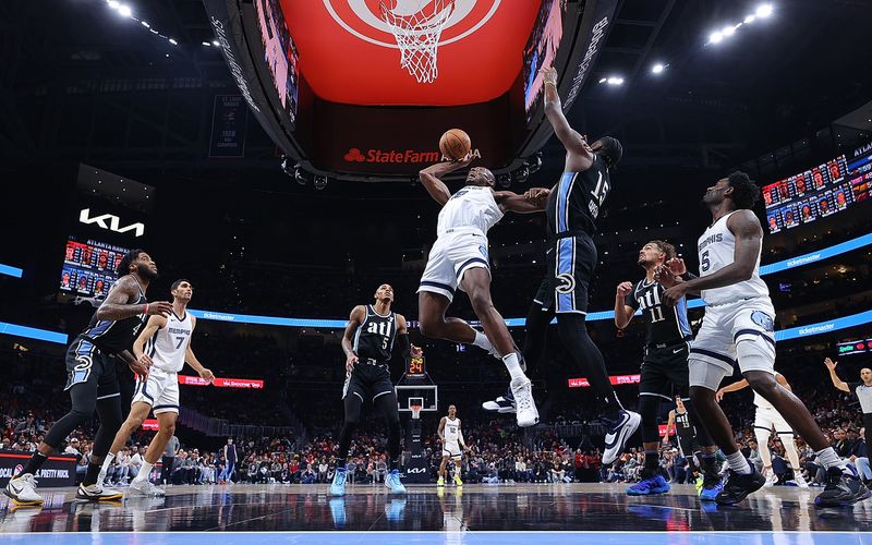 ATLANTA, GEORGIA - DECEMBER 23:  Bismack Biyombo #18 of the Memphis Grizzlies draws a foul as he attacks the basket against Clint Capela #15 of the Atlanta Hawks during the fourth quarter at State Farm Arena on December 23, 2023 in Atlanta, Georgia.  NOTE TO USER: User expressly acknowledges and agrees that, by downloading and/or using this photograph, user is consenting to the terms and conditions of the Getty Images License Agreement. (Photo by Kevin C. Cox/Getty Images)