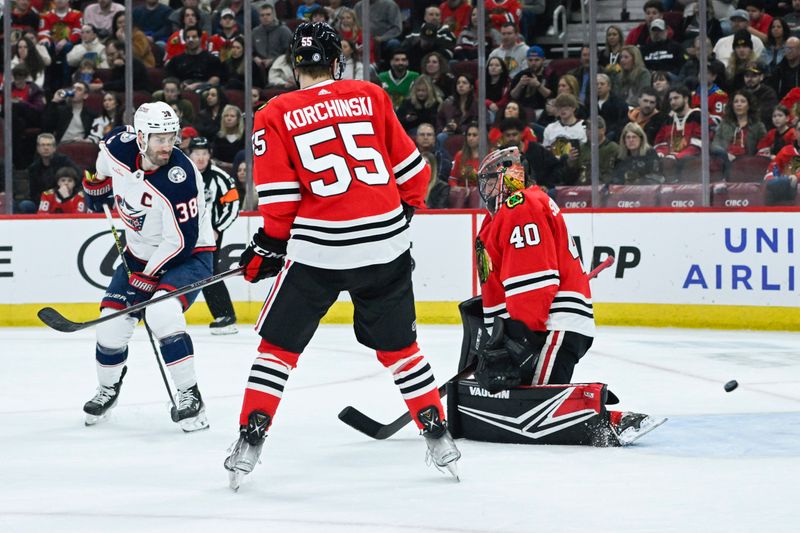 Mar 2, 2024; Chicago, Illinois, USA;  Columbus Blue Jackets center Boone Jenner (38) scores a goal past Chicago Blackhawks defenseman Kevin Korchinski (55) and Chicago Blackhawks goaltender Arvid Soderblom (40) during the first period at the  United Center. Mandatory Credit: Matt Marton-USA TODAY Sports