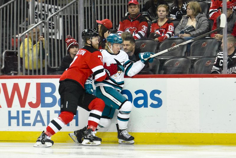 Nov 10, 2024; Newark, New Jersey, USA; San Jose Sharks left wing Fabian Zetterlund (20) tries to get past New Jersey Devils defenseman Dougie Hamilton (7) during the first period at Prudential Center. Mandatory Credit: John Jones-Imagn Images