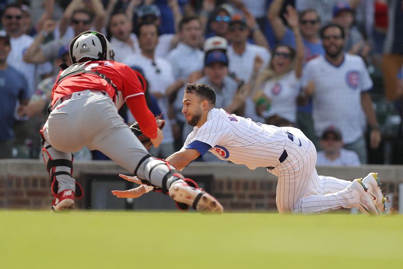 May 31, 2024; Chicago, Illinois, USA; Chicago Cubs third baseman Nick Madrigal (1) slides into home plate as Cincinnati Reds catcher Tyler Stephenson (37) reaches for the tag during the ninth inning at Wrigley Field. Mandatory Credit: Melissa Tamez-USA TODAY Sports