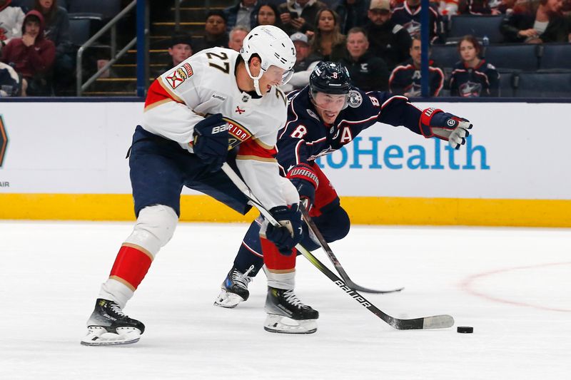 Oct 15, 2024; Columbus, Ohio, USA; Columbus Blue Jackets defenseman Zach Werenski (8) attempts to stick the puck away from Florida Panthers center Eetu Luostarinen (27) during the third period at Nationwide Arena. Mandatory Credit: Russell LaBounty-Imagn Images