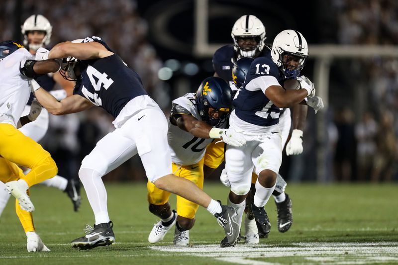 Sep 2, 2023; University Park, Pennsylvania, USA; Penn State Nittany Lions running back Kaytron Allen (13) avoids a tackle while running with the ball during the second quarter against the West Virginia Mountaineers at Beaver Stadium. Mandatory Credit: Matthew O'Haren-USA TODAY Sports