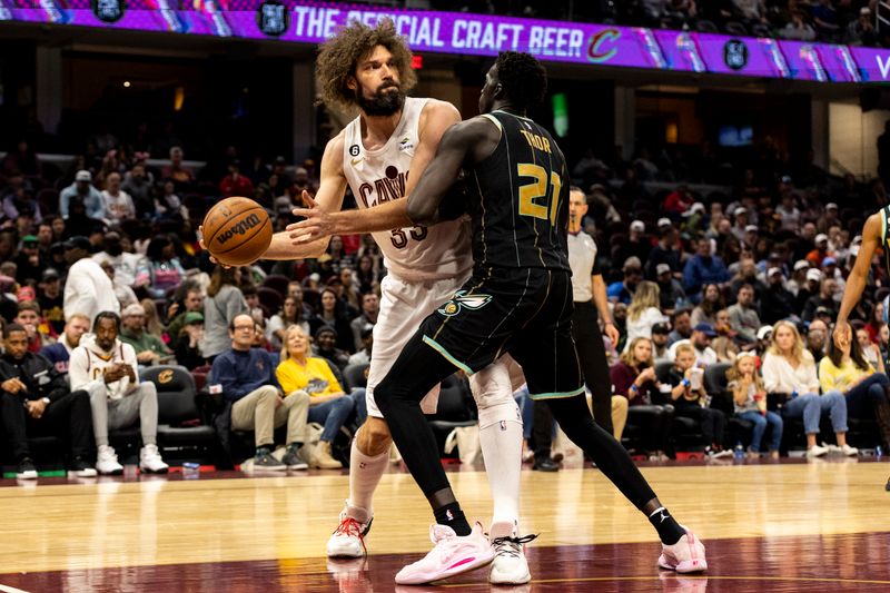 CLEVELAND, OH - APRIL 09: Robin Lopez #33 of the Cleveland Cavaliers passes the ball around JT Thor #21 of the Charlotte Hornets during the game at Rocket Mortgage Fieldhouse on April 9, 2023 in Cleveland, Ohio. The Hornets beat the Cavaliers 106-95. NOTE TO USER: User expressly acknowledges and agrees that, by downloading and/or using this Photograph, user is consenting to the terms and conditions of the Getty Images License Agreement. (Photo by Lauren Leigh Bacho/Getty Images)