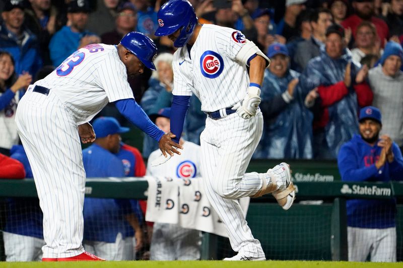 Sep 19, 2023; Chicago, Illinois, USA; Chicago Cubs right fielder Seiya Suzuki (27) is greeted by third base coach Willie Harris (33) after hitting a home run against the Pittsburgh Pirates during the third inning at Wrigley Field. Mandatory Credit: David Banks-USA TODAY Sports