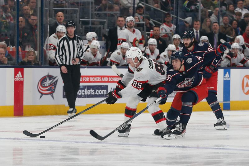 Dec 1, 2023; Columbus, Ohio, USA; Ottawa Senators defenseman Jake Sanderson (85) controls the puck as Columbus Blue Jackets right wing Yegor Chinakhov (59) trails the play during the third period at Nationwide Arena. Mandatory Credit: Russell LaBounty-USA TODAY Sports