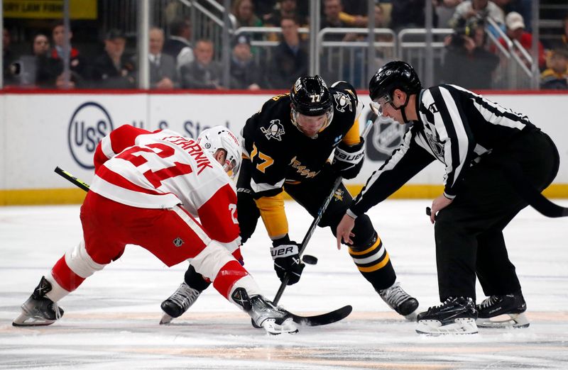 Apr 11, 2024; Pittsburgh, Pennsylvania, USA; Detroit Red Wings center Austin Czarnik (21) and Pittsburgh Penguins center Jeff Carter (77) take a face-off during the first period at PPG Paints Arena. Mandatory Credit: Charles LeClaire-USA TODAY Sports