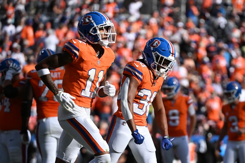 Denver Broncos running back Jaleel McLaughlin (38) and teammate wide receiver Josh Reynolds (11) run to the sideline after McLaughlin's 4-yard reception for a touchdown during the second half of an NFL football game against the Las Vegas Raiders, Sunday, Oct. 6, 2024, in Denver. (AP Photo/Geneva Heffernan)