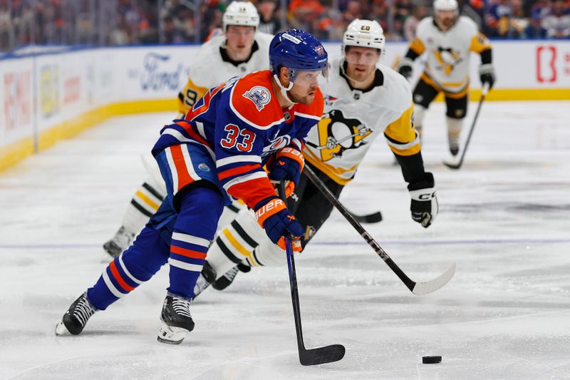 Oct 25, 2024; Edmonton, Alberta, CAN; Edmonton Oilers forward Victor Arvidsson (33) clears a puck in front of Pittsburgh Penguins forward Lars Eller (20) during the second period at Rogers Place. Mandatory Credit: Perry Nelson-Imagn Images