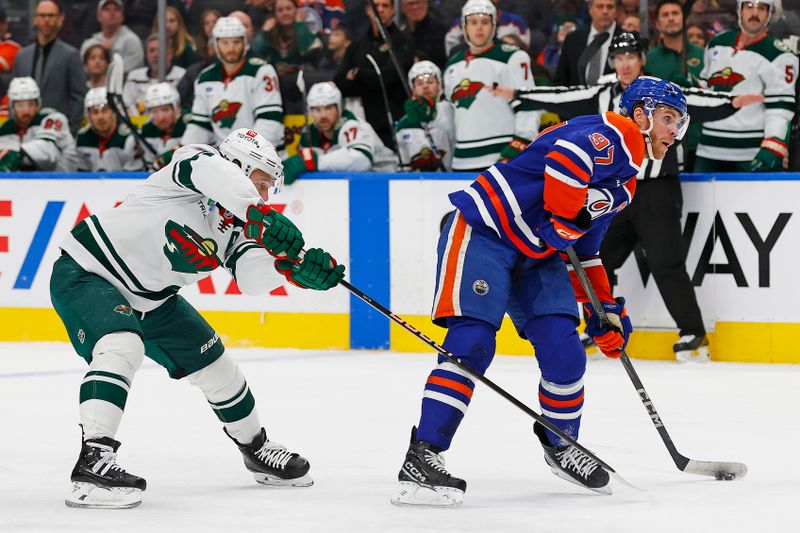 Nov 21, 2024; Edmonton, Alberta, CAN; Minnesota Wild forward Kirill Kaprizov (97) tries to stop Edmonton Oilers forward Connor McDavid (97) from taking a shot during the first period at Rogers Place. Mandatory Credit: Perry Nelson-Imagn Images