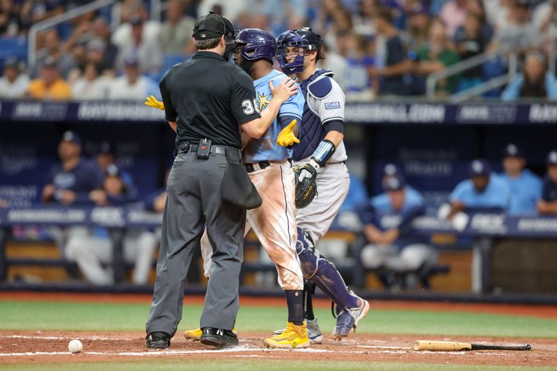 Aug 27, 2023; St. Petersburg, Florida, USA;  umpire Mike Estabrook (83) holds back Tampa Bay Rays left fielder Randy Arozarena (56) after being hit by a pitch against the New York Yankees in the eighth inning at Tropicana Field. Mandatory Credit: Nathan Ray Seebeck-USA TODAY Sports