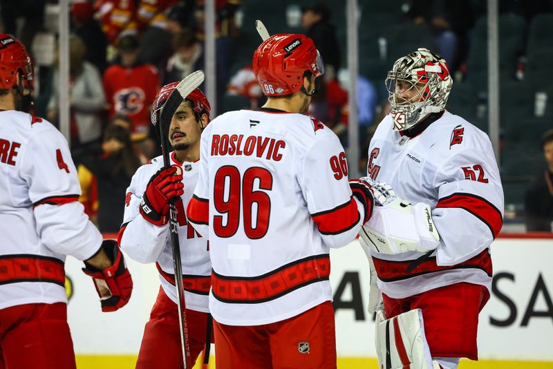 Oct 24, 2024; Calgary, Alberta, CAN; Carolina Hurricanes goaltender Pyotr Kochetkov (52) celebrate win with teammates after defeating the.Calgary Flames at Scotiabank Saddledome. Mandatory Credit: Sergei Belski-Imagn Images