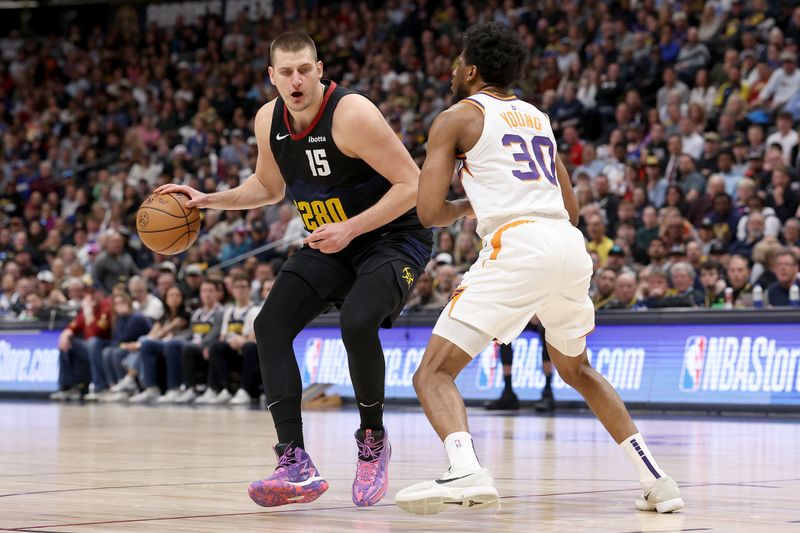 DENVER, COLORADO - MARCH 27: Nikola Jokic #15 of the Denver Nuggets drives against Thaddeus Young #30 of the Phoenix Suns during the fourth quarter at Ball Arena on March 27, 2024 in Denver, Colorado. NOTE TO USER: User expressly acknowledges and agrees that, by downloading and or using this photograph, User is consenting to the terms and conditions of the Getty Images License Agreement.  (Photo by Matthew Stockman/Getty Images)