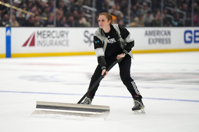 Dec 20, 2023; Los Angeles, California, USA; A LA Kings female ice crew members clears the ice against the Seattle Kraken in the first period at Crypto.com Arena. Mandatory Credit: Kirby Lee-USA TODAY Sports