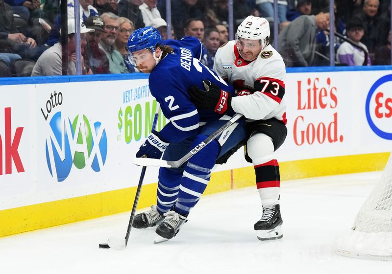 Nov 12, 2024; Toronto, Ontario, CAN; Toronto Maple Leafs defenseman Simon Benoit (2) battles for the puck with Ottawa Senators left wing Noah Gregor (73) during the second period at Scotiabank Arena. Mandatory Credit: Nick Turchiaro-Imagn Images