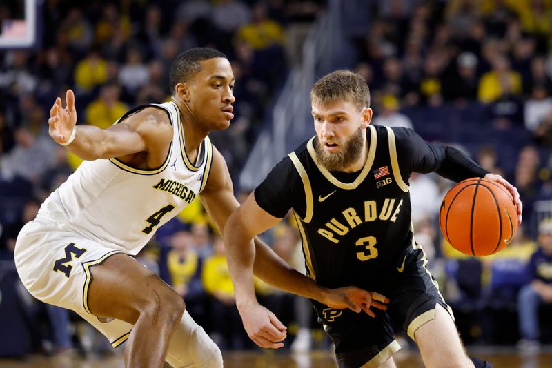 Feb 11, 2025; Ann Arbor, Michigan, USA;  Purdue Boilermakers guard Braden Smith (3) dribbles defended by Michigan Wolverines guard Nimari Burnett (4) in the second half at Crisler Center. Mandatory Credit: Rick Osentoski-Imagn Images