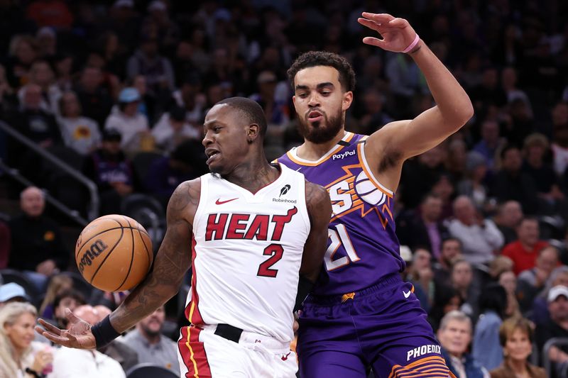 PHOENIX, ARIZONA - NOVEMBER 06: Terry Rozier #2 of the Miami Heat bobbles the ball under pressure from Tyus Jones #21 of the Phoenix Suns during the first half at Footprint Center on November 06, 2024 in Phoenix, Arizona. NOTE TO USER: User expressly acknowledges and agrees that, by downloading and or using this photograph, User is consenting to the terms and conditions of the Getty Images License Agreement.  (Photo by Chris Coduto/Getty Images)