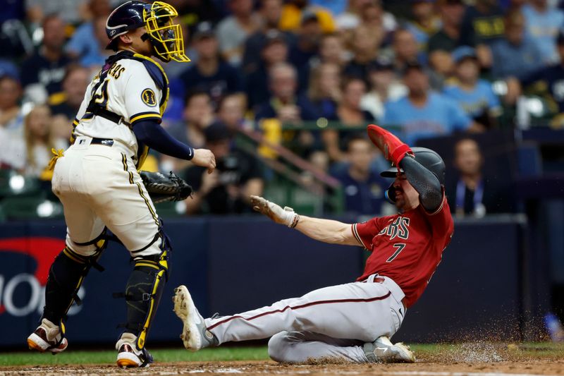 Oct 4, 2023; Milwaukee, Wisconsin, USA; Arizona Diamondbacks left fielder Corbin Carroll (7) slides home to score in the sixth inning against Milwaukee Brewers catcher William Contreras (24) during game two of the Wildcard series for the 2023 MLB playoffs at American Family Field. Mandatory Credit: Kamil Krzaczynski-USA TODAY Sports