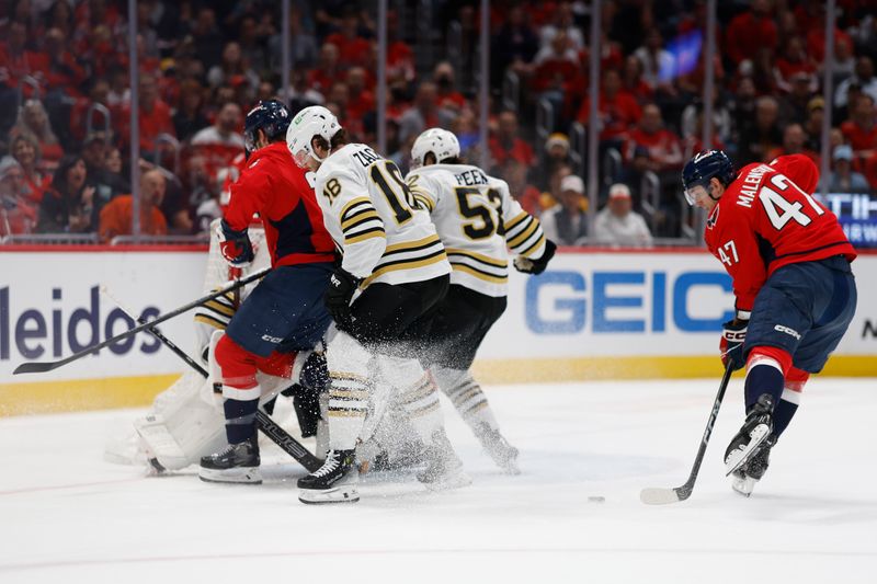 Apr 15, 2024; Washington, District of Columbia, USA; Washington Capitals left wing Beck Malenstyn (47) shoots the puck on Boston Bruins goaltender Jeremy Swayman (1)  as Bruins defenseman Andrew Peeke (52) defends in the first period at Capital One Arena. Mandatory Credit: Geoff Burke-USA TODAY Sports