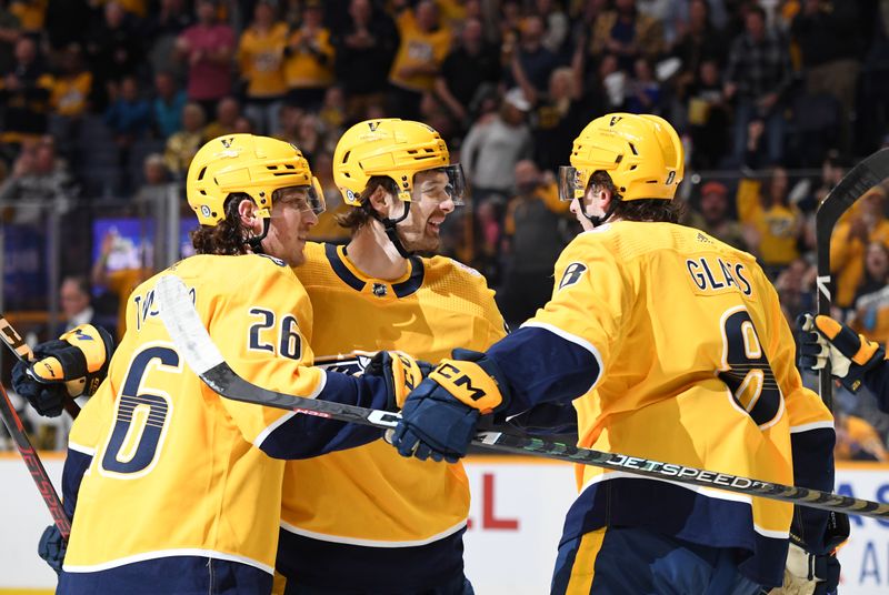 Apr 4, 2023; Nashville, Tennessee, USA; Nashville Predators center Tommy Novak (82) celebrates with teammates after his second goal of the first period against the Vegas Golden Knights at Bridgestone Arena. Mandatory Credit: Christopher Hanewinckel-USA TODAY Sports