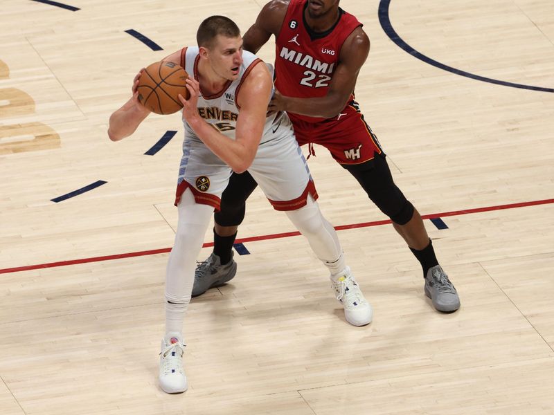 DENVER, CO - JUNE 12: Nikola Jokic #15 of the Denver Nuggets handles the ball against defender Jimmy Butler #22 of the Miami Heat during Game Five of the 2023 NBA Finals on June 12, 2023 at Ball Arena in Denver, Colorado. NOTE TO USER: User expressly acknowledges and agrees that, by downloading and or using this Photograph, user is consenting to the terms and conditions of the Getty Images License Agreement. Mandatory Copyright Notice: Copyright 2023 NBAE (Photo by Ben Swanson/NBAE via Getty Images)