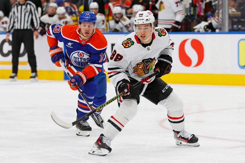 Oct 12, 2024; Edmonton, Alberta, CAN; Chicago Blackhawks forward Connor Bedard (98) looks for a pass in front of Edmonton Oilers forward Mattias Janmark (13) during the second period at Rogers Place. Mandatory Credit: Perry Nelson-Imagn Images