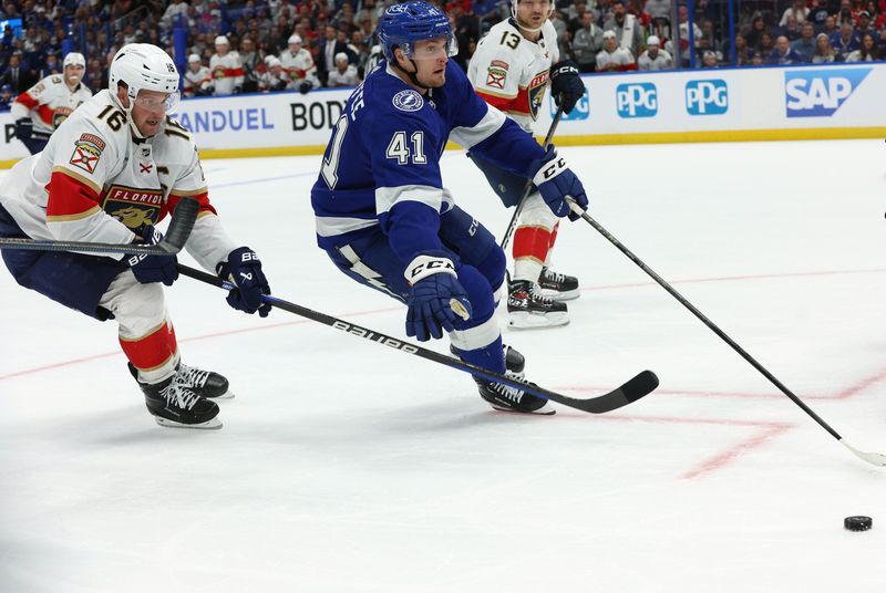 Apr 27, 2024; Tampa, Florida, USA; Tampa Bay Lightning right wing Mitchell Chaffee (41) skates with the puck as Florida Panthers center Aleksander Barkov (16) defends during the third period in game four of the first round of the 2024 Stanley Cup Playoffs at Amalie Arena. Mandatory Credit: Kim Klement Neitzel-USA TODAY Sports